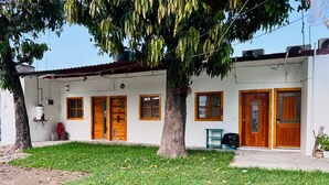 A two-story building with a white exterior, wooden doors, and windows.