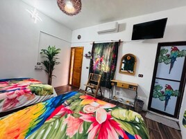 Un dormitorio con dos camas, un televisor, un espejo y una puerta.