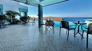 A rooftop terrace with a pool, lounge chairs, and a view of the sea. - Miromara Hotel Karaburun (Karaburun)