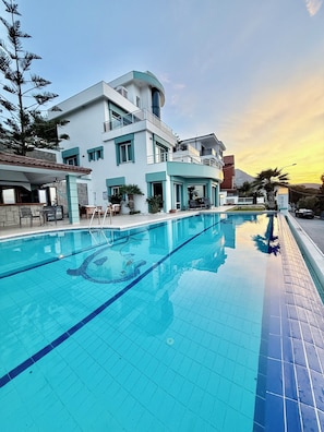 A modern building with a swimming pool, outdoor seating, and a mountain in the background. - Miromara Hotel Karaburun (Karaburun)