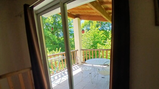 A room with a sliding glass door leading to an outdoor patio with a table and chairs.
