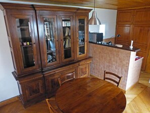 Enjoy meals at the round dining table with four chairs, surrounded by wooden cabinetry and an island.