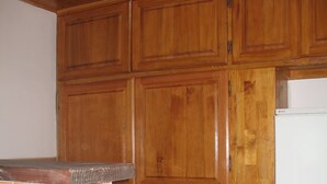 A kitchen with wooden cabinets, a tiled backsplash, and a white refrigerator.