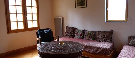 Una habitación acogedora con techo de madera, una mesa redonda, un sofá y una cama.