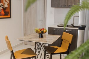 Una cucina moderna con un piano di lavoro in marmo, una ciotola di frutta e due sedie.