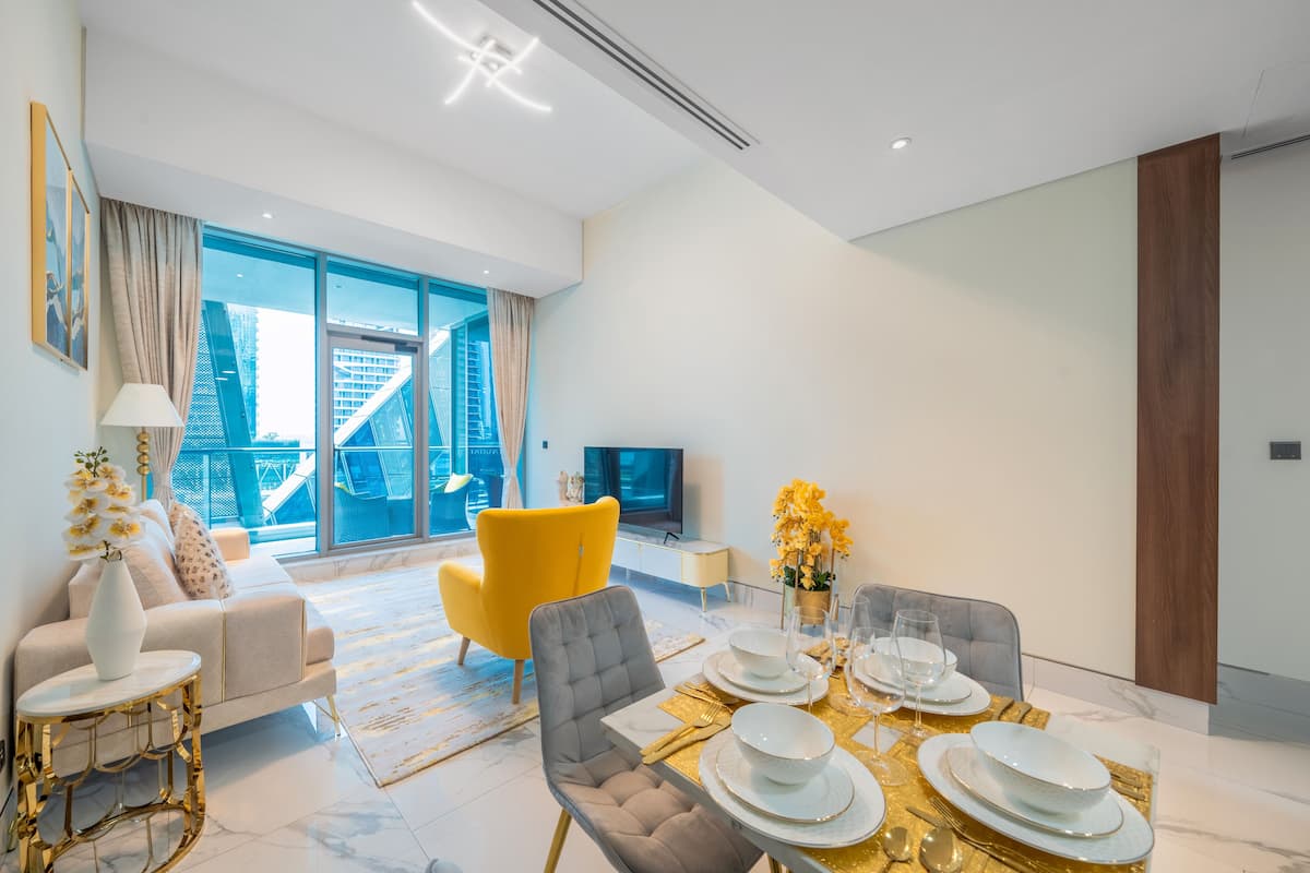 A modern living room with a dining area, large windows, and a view of a cityscape.