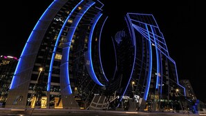 A modern building with curved glass facades and blue lighting accents. - SIMPLY COMFORT Urban Chic Suites in J One Tower City & Canal Views (Dubai)