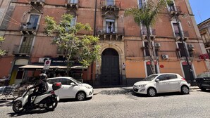 A building with a traditional facade, featuring a central entrance with a black door, multiple balconies, and a sign for 'Salumeria Pias'. - Dimore del Plebiscito B&B (Catania)