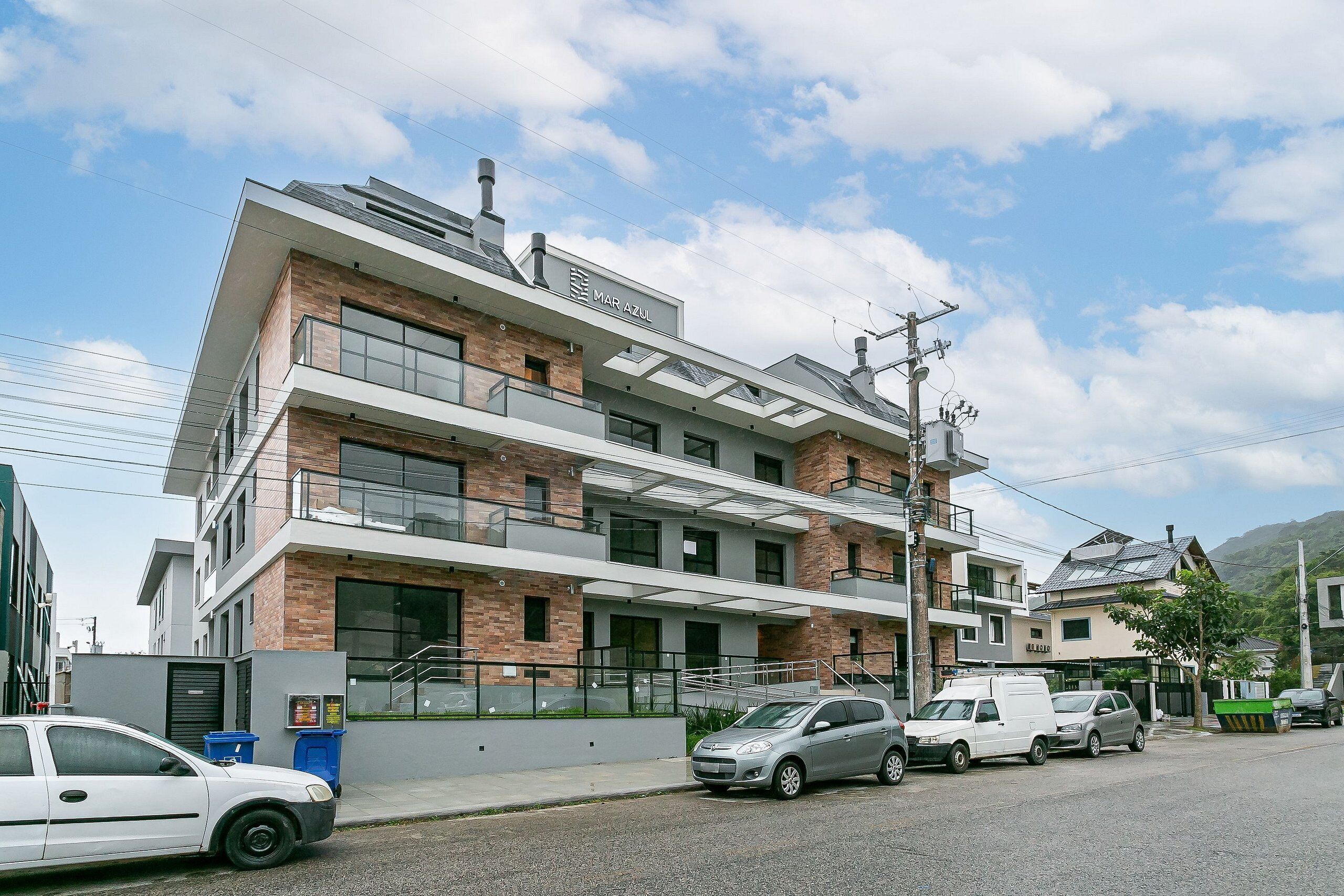 A multi-story building with a modern design, featuring a prominent 'MAR AZUL' sign on the top floor.