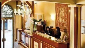 A reception desk with a chandelier, a mirror, and a floral arrangement. - The Venice Times (Venice)