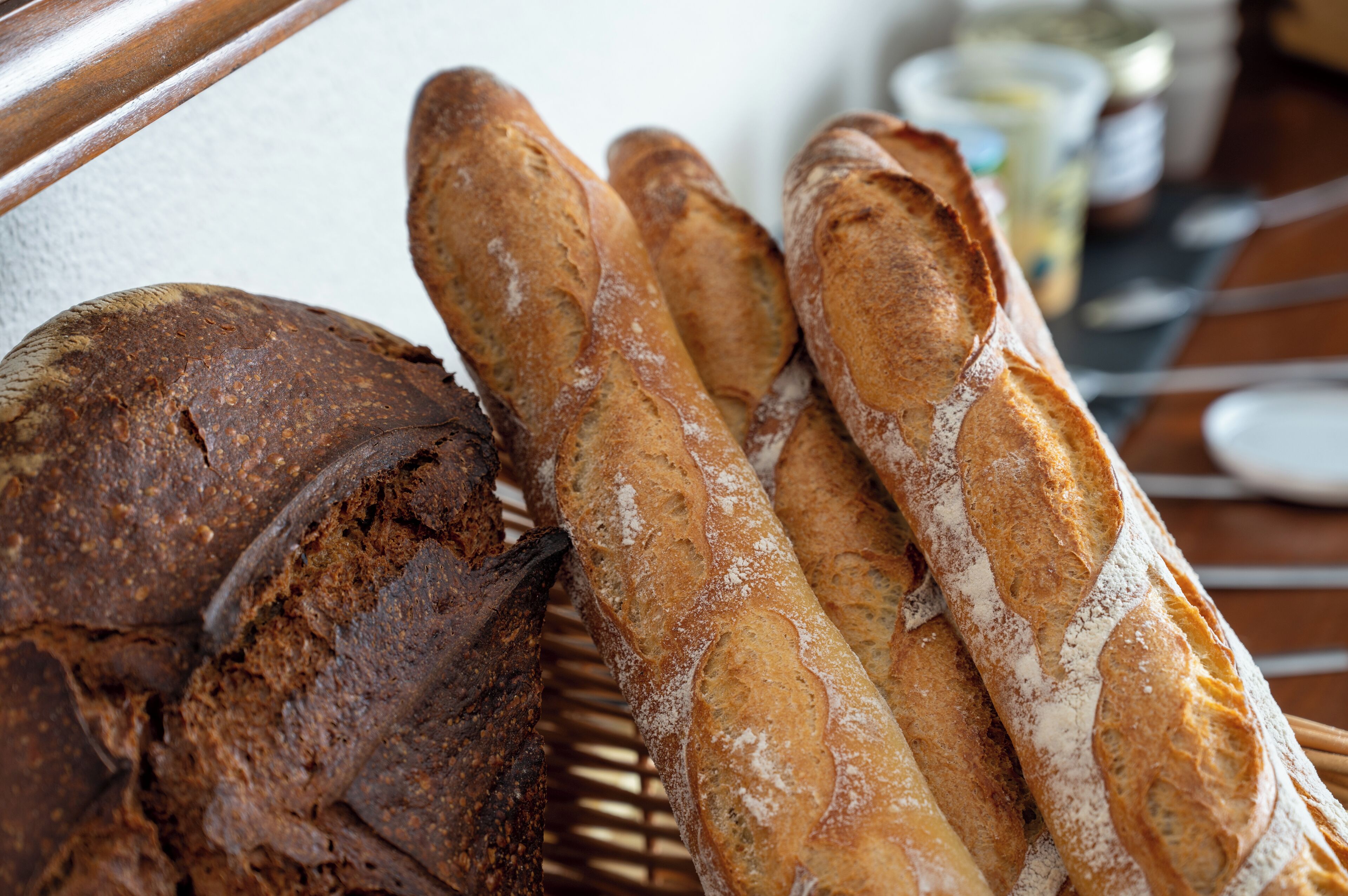 Een brood en verschillende stokbroden op een houten oppervlak.