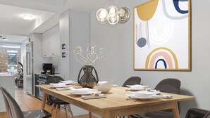 Un comedor moderno con una mesa de madera, sillas y un jarrón decorativo.