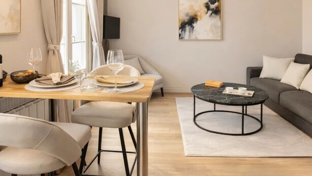 A modern living room with a dining area, a sofa, a coffee table, and a ceiling fan. - VIERGE (Paris)