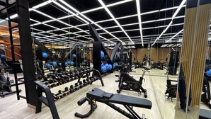 A gym with various exercise equipment, including dumbbells, benches, and cardio machines. - Suite XOE in front of Carolina Park - 11th floor (Quito)