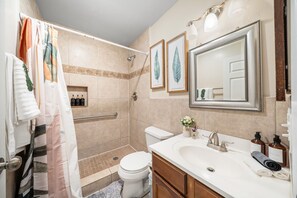 Une salle de bain équipée d’une douche, de toilettes, d’un lavabo et d’un meuble-lavabo.