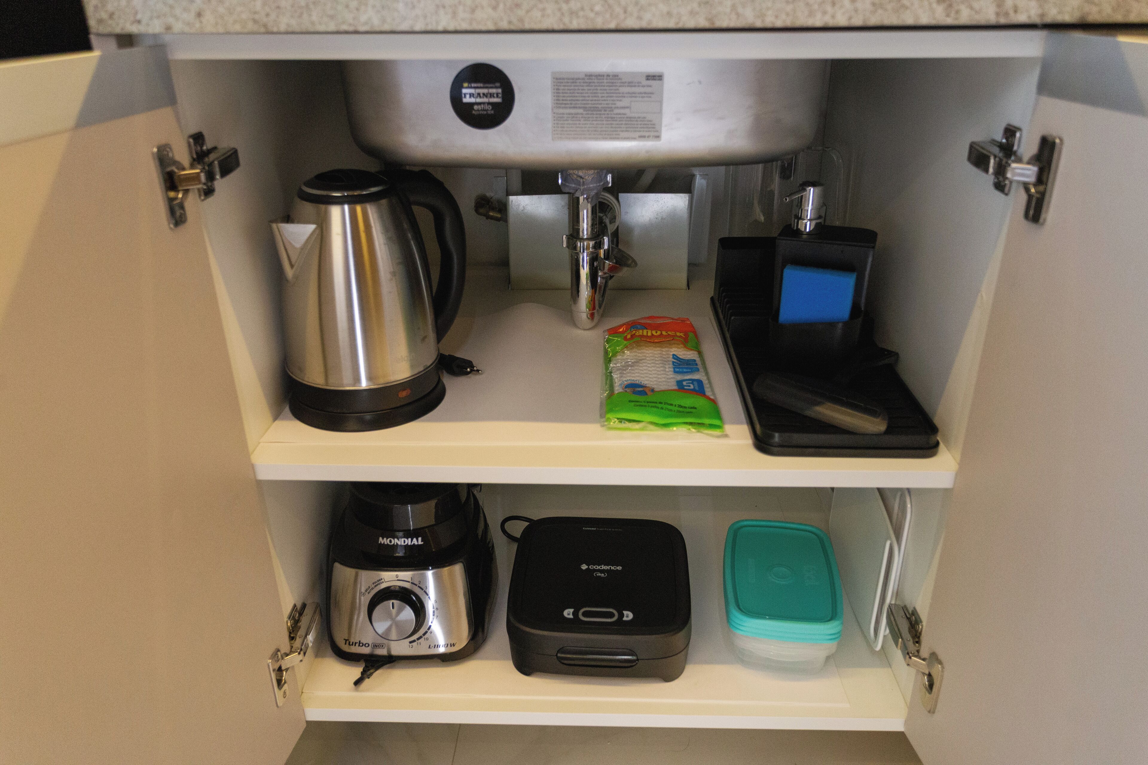 A kitchen with a coffee maker, a blender, a toaster, and a small appliance on the countertop.