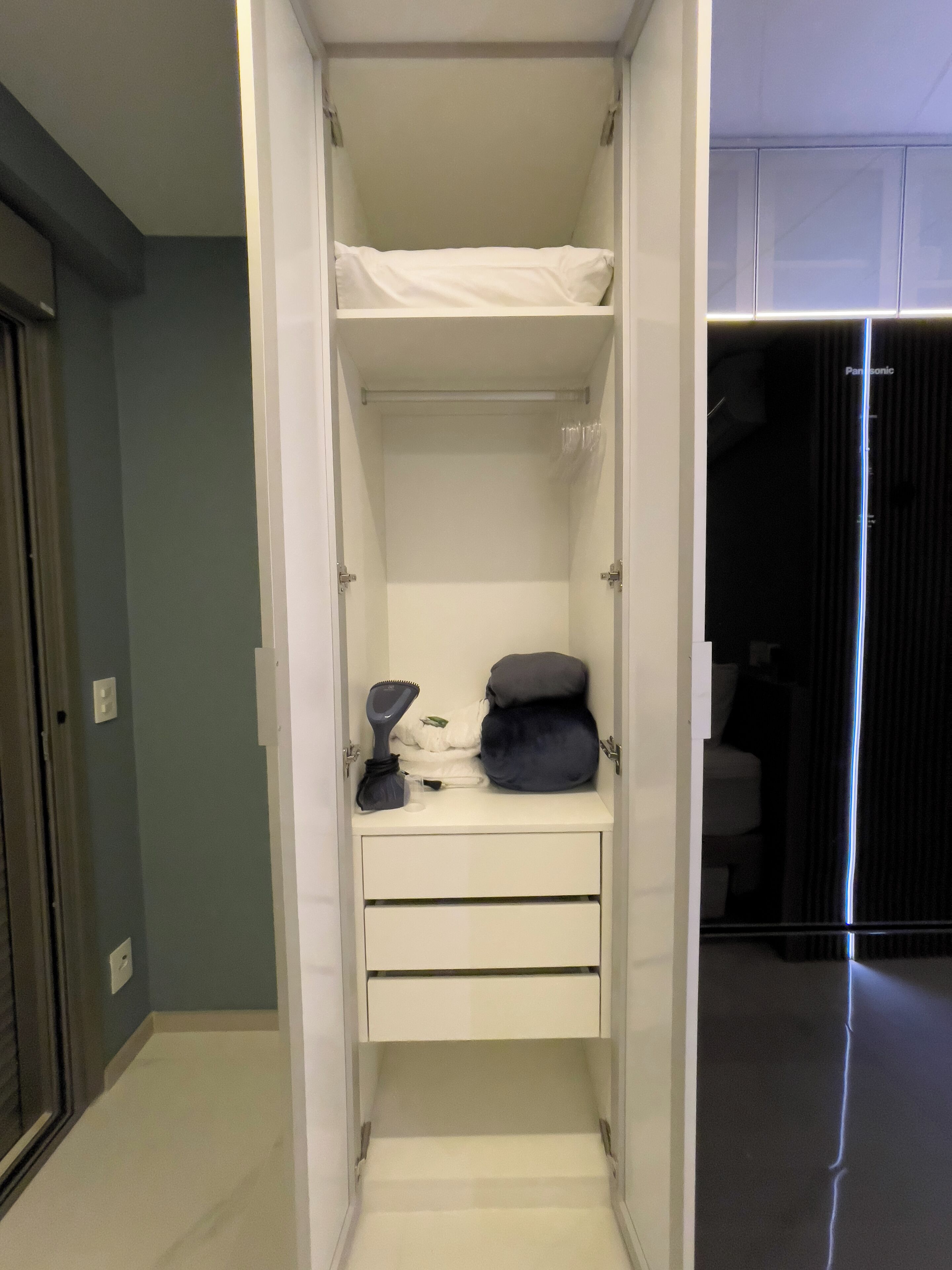 Un dressing avec un lit, des tiroirs et un espace pour suspendre les vêtements.