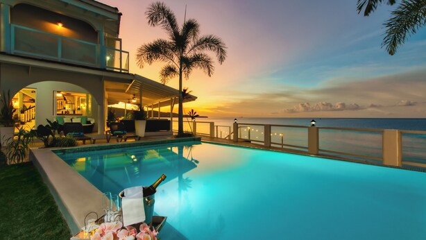 A luxurious pool area with a view of the ocean, a covered seating area, and a well-lit outdoor space. - Spacious 5-bedroom villa w/ Private Beach Access 1 minute away in, St. Ann (St. Ann)