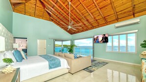 A spacious bedroom with a large bed, a ceiling fan, and a view of the ocean. - Spacious 5-bedroom villa w/ Private Beach Access 1 minute away in, St. Ann (St. Ann)