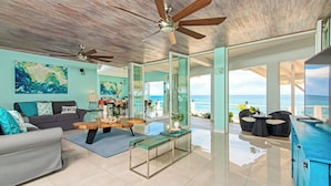 A spacious living area with a ceiling fan, a sofa, a coffee table, and a view of the ocean. - Spacious 5-bedroom villa w/ Private Beach Access 1 minute away in, St. Ann (St. Ann)