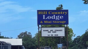 Une enseigne pour le Hill Country Lodge & Mini Storage, avec un numéro de téléphone à contacter.