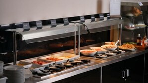 Ein Buffet mit ausgewiesenen Bereichen für verschiedene Speisen, darunter eine Auswahl an Gerichten und Beilagen.