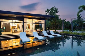 A modern hotel with a swimming pool, sun loungers, and a well-lit interior. - Huge Pool Villa with Private Lake 4BR/10 Persons (Banglamung)