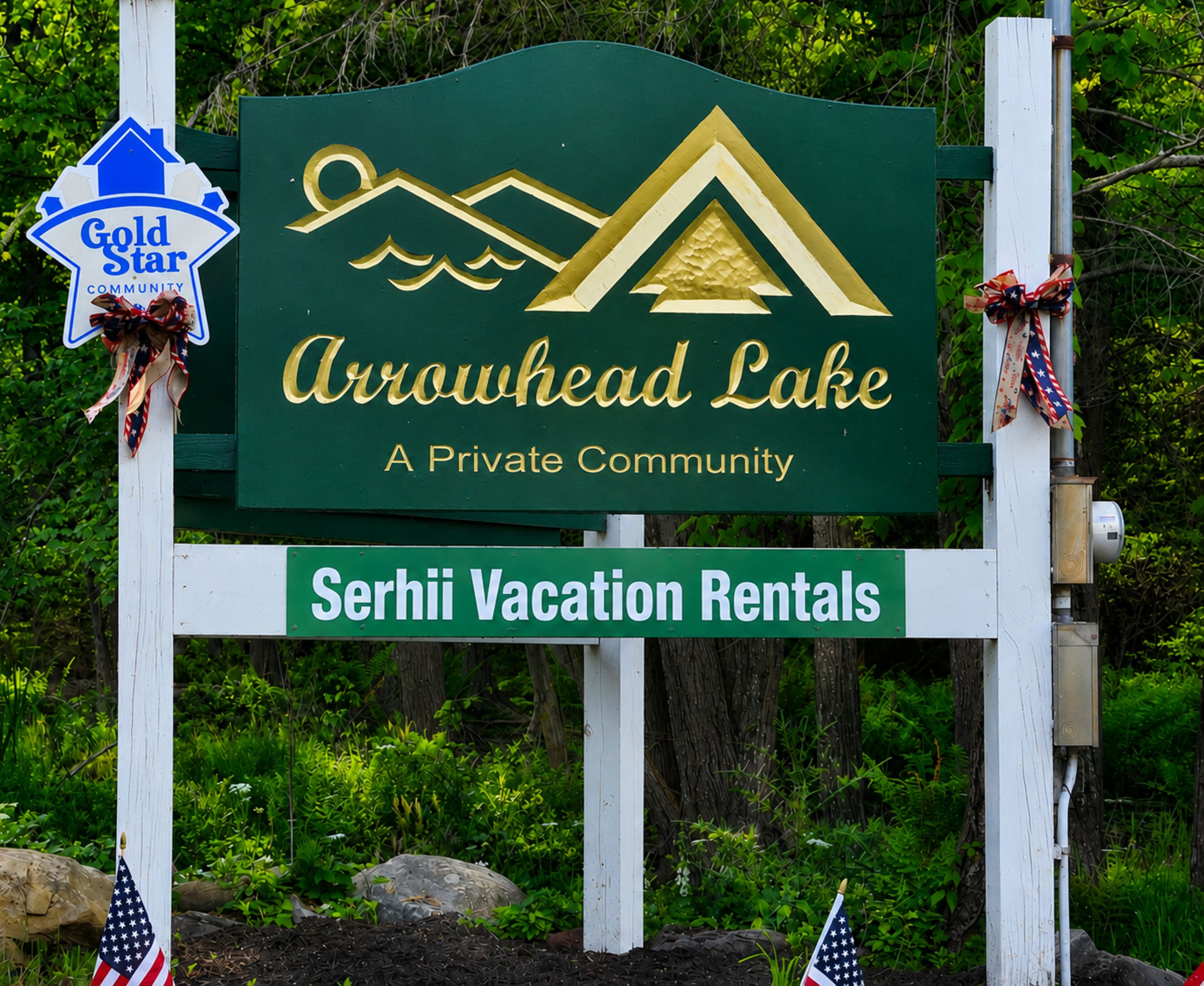 A sign for Arrowhead Lake, a private community, with a Serhii Vacation Rentals sign below.