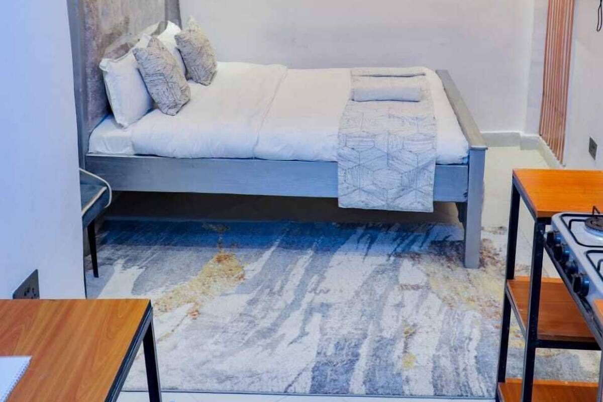 Un dormitorio moderno con cama, escritorio y silla.