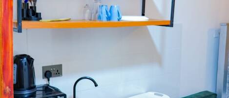 A compact kitchenette with a Bosch microwave, a sink, and a small countertop.