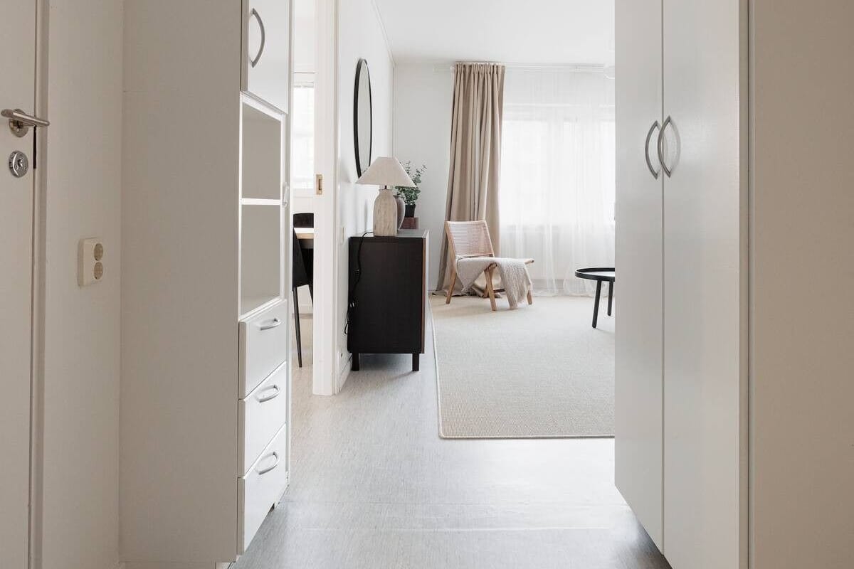 A modern bedroom with a large wardrobe, a bedside table, a chair, and a bed.