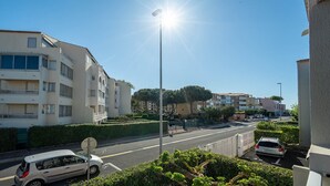 A residential street with apartment buildings, a clear sky, and parked cars. - Apartment in Agde Near Beach & Heated Pool (Agde)