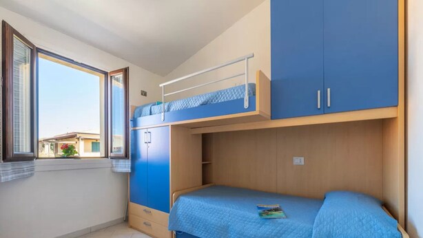 A dormitory room with bunk beds, a window, and a view of the outside. - Cozy Flat Just Steps From Baia Delle Mimose (Badesi)