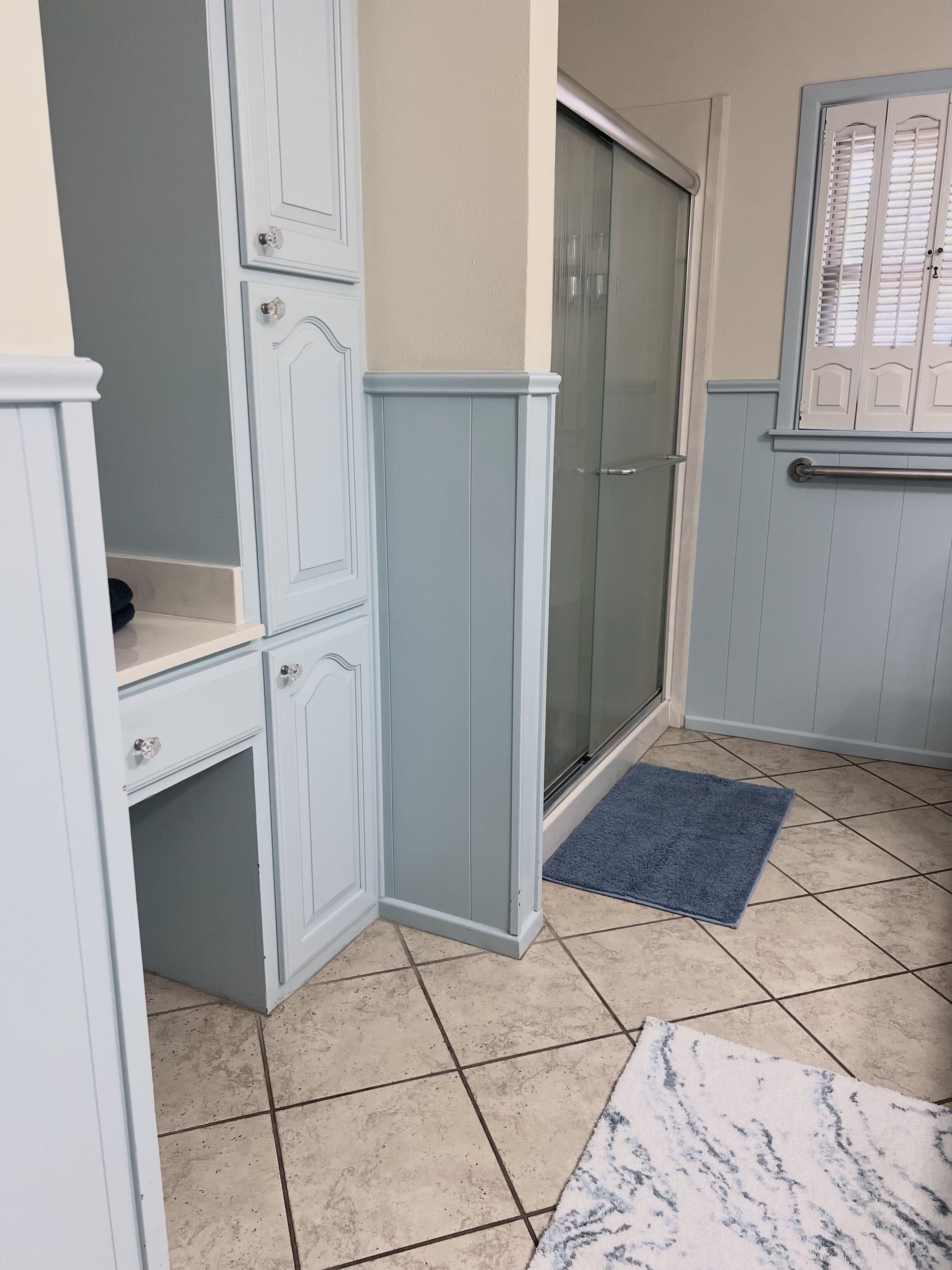 Uma casa de banho com chuveiro, porta-toalhas e sanita.