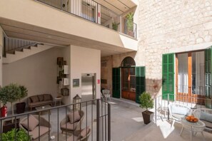 A multi-level apartment with a staircase, outdoor seating area, and a balcony. - Soller Plaza (Soller)
