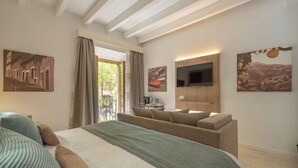 A modern hotel room with a large bed, a sofa, a TV, and artwork on the walls. - Soller Plaza (Soller)