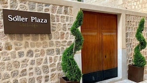A stone facade with a wooden door and a sign reading "Söller Plaza hotel boutique". - Soller Plaza (Soller)