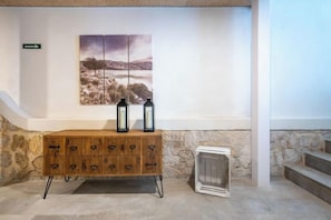 Un mobile in legno con due lanterne, un termosifone e un quadro appeso al muro.