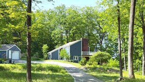 Una casa a due piani con garage visibile e vialetto lastricato che conduce all'ingresso.