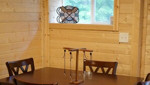 Ein Holzespeisetisch mit sechs Stühlen, ein Fenster mit Blick auf Bäume und eine Wanddekoration zum Thema Baseball.