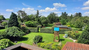 A well-maintained garden with a wooden play structure, a swimming pool, and a variety of greenery. - FeWo am Dachsberg, DTV certified with 3 stars (Kamp-Lintfort)