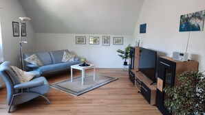 A modern living room with a sofa, a coffee table, a TV, and a radio. - FeWo am Dachsberg, DTV certified with 3 stars (Kamp-Lintfort)
