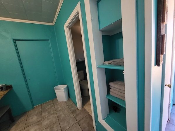 Een douche, handdoeken, zeep, toiletpapier