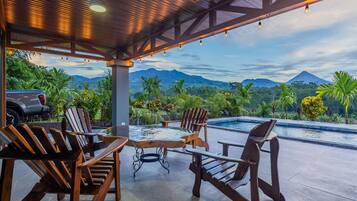 Relax in a serene outdoor space with a clear view of the surrounding landscape and a mountain in the distance.