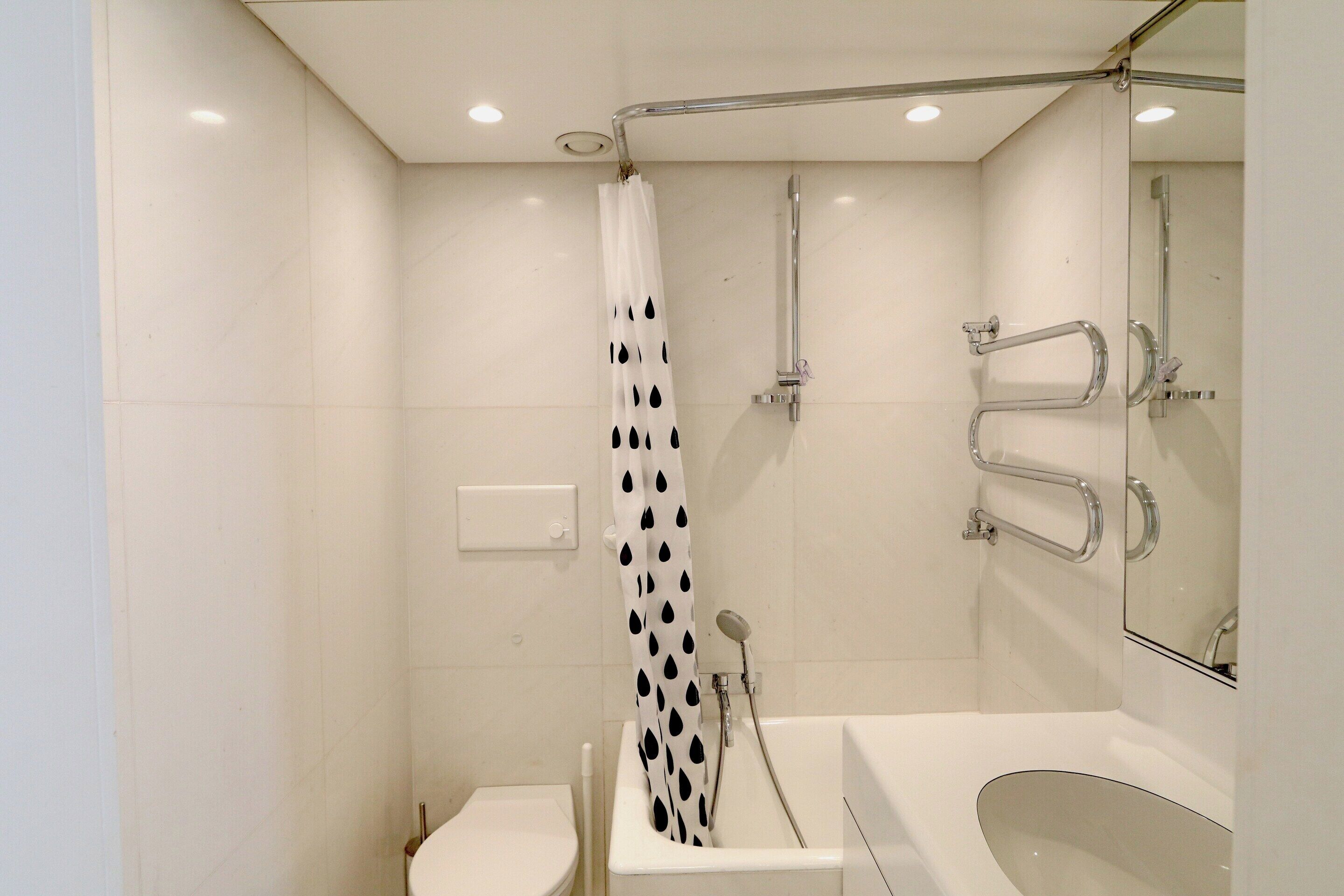 A modern bathroom with a shower, toilet, and sink.