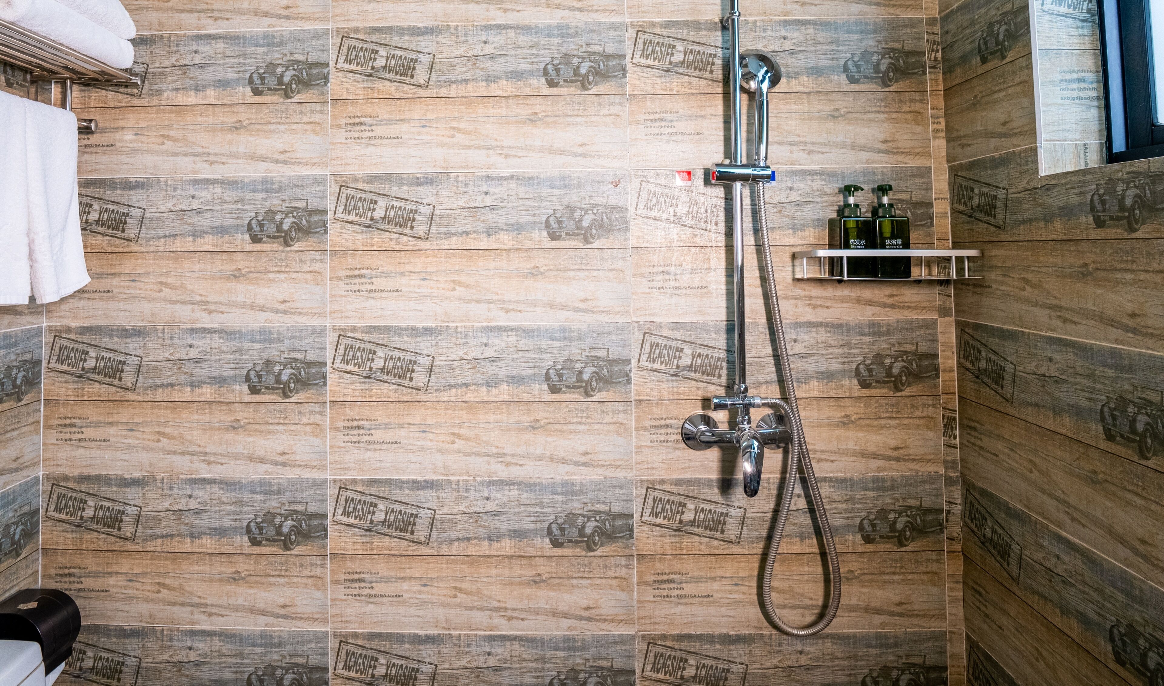 A shower with a handheld hose and a wall-mounted faucet.