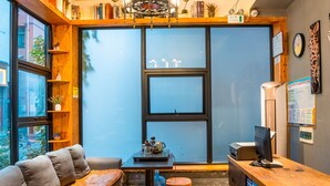 Una habitación acogedora con techo de madera, un sofá, una mesita y un escritorio con una computadora.
