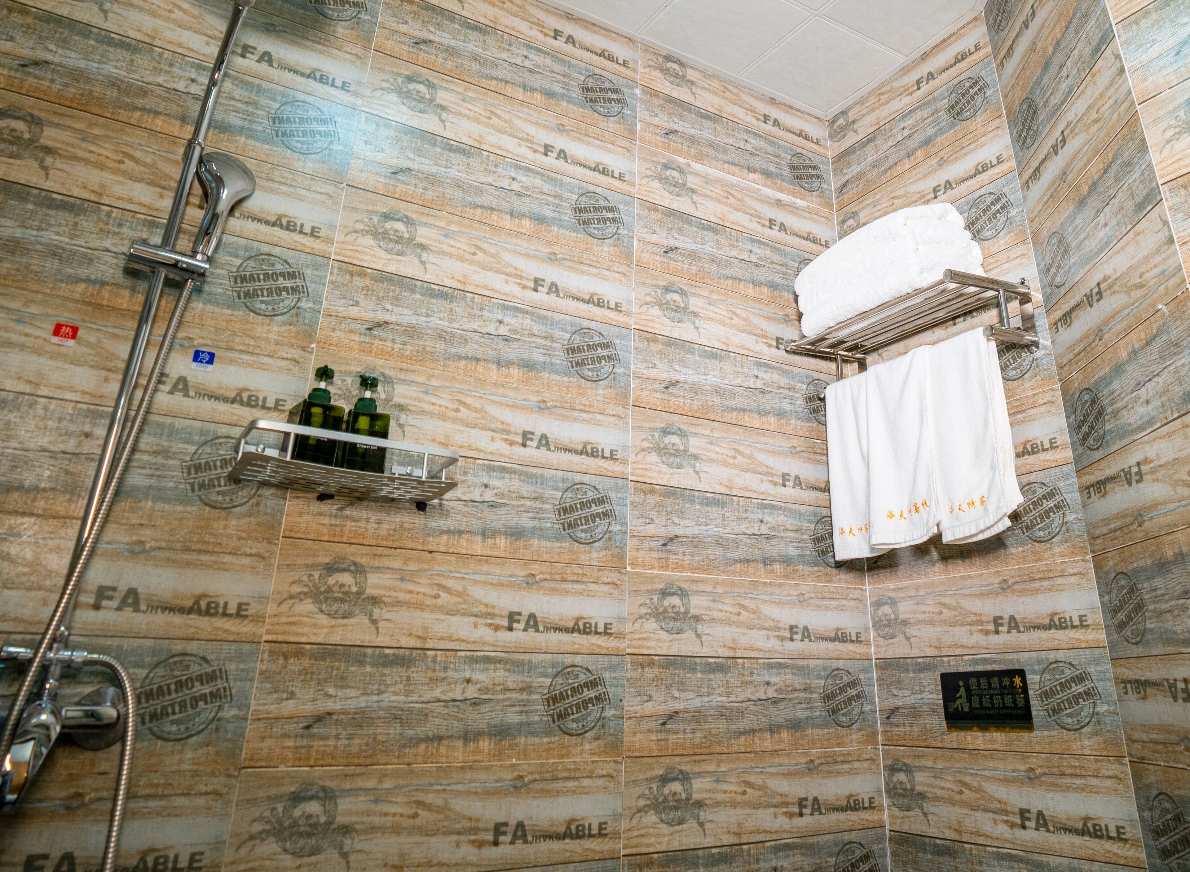 A bathroom with a shower, a towel rack, and a shelf with bottles.