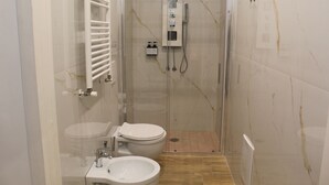 Ein modernes Badezimmer mit einer Duschkabine aus Glas, einer Toilette und einem Waschbecken.