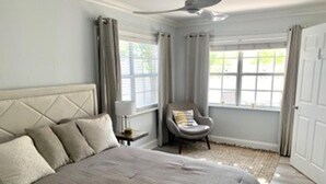 A bedroom with a large bed, a chair, and a window with curtains. - House - Sleeps 6 - Hot Tub - Garden - Near Beach (Naples)